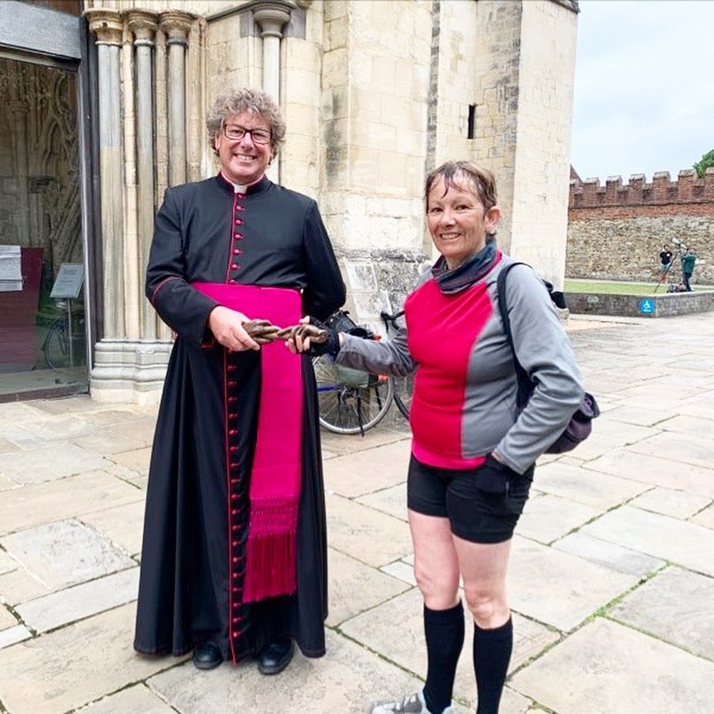 The Dean of Chichester holds a bronze baton with a cyclist