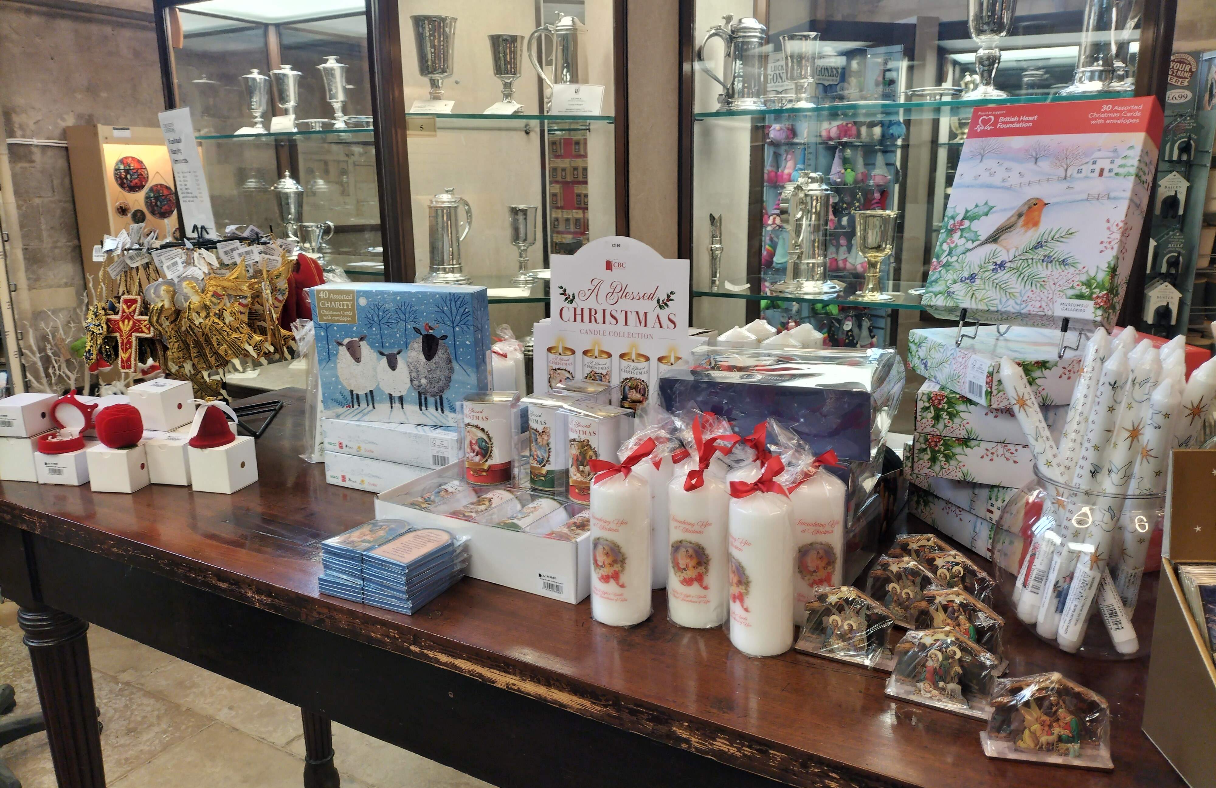 A selection of Christmas gifts including candles, nativity decorations on a table.