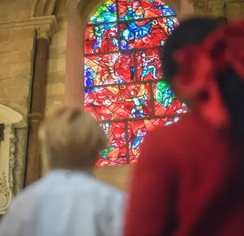 children look at stained glass window