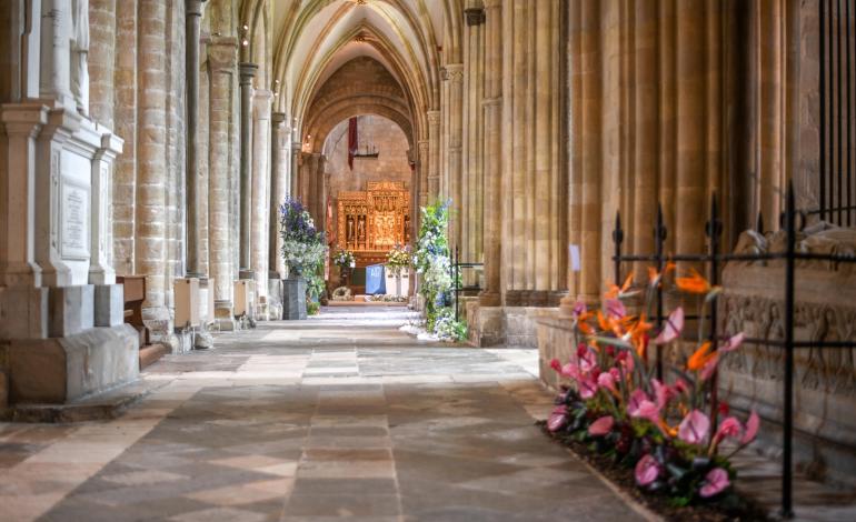 Cathedral aisles adorned with bright orange and pink flowers